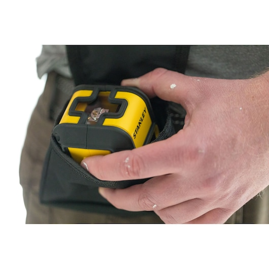 Photo of STANLEY STHT77648-1 laser level being placed in a carrying pouch, close-up view.