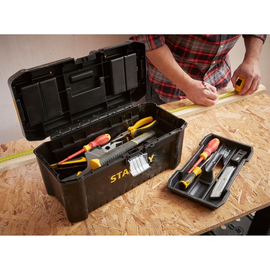 STANLEY STST1-75518-KR black toolbox open with assorted tools, tray beside, shown on workbench.