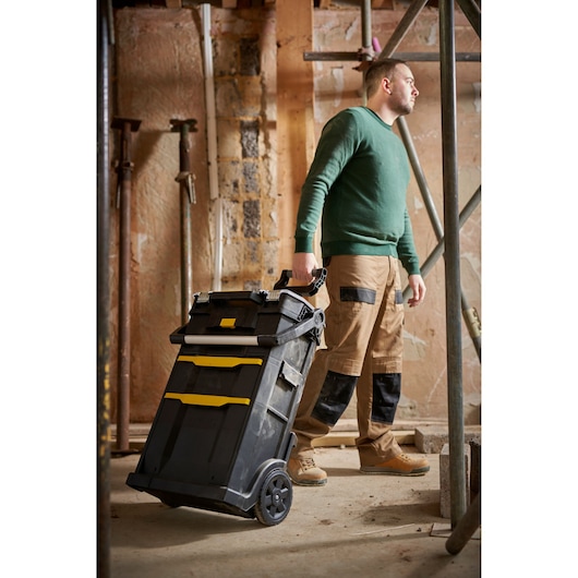 STANLEY STST1-79231 mobile tool chest with yellow accents, shown in use at a construction site.