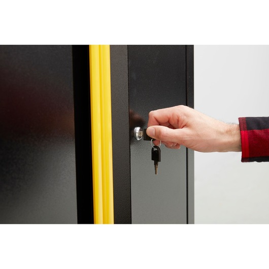 STANLEY STST97595-1 cabinet with yellow trim, close-up of lock and hand turning key, product photography.